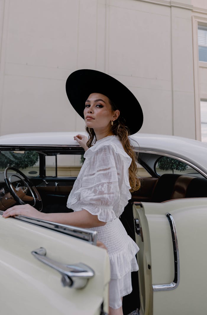 Woman in Hat Posing by Vintage Car